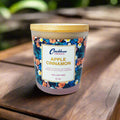 Candle with floral label and 'Caribbean Emerald' branding on a white background